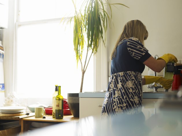 howard/photodisc/getty images a woman is cleaning up the kitchen