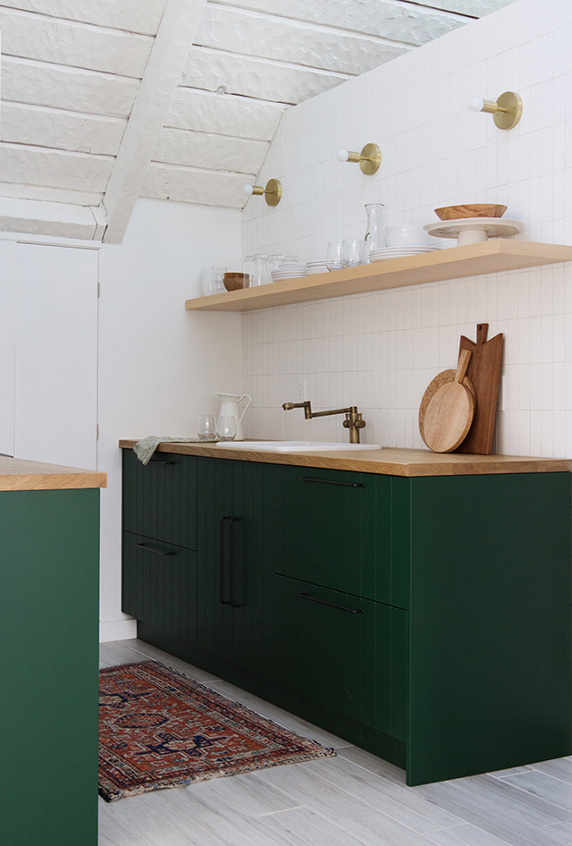 Grey kitchen cabinets against sage green walls in an attic