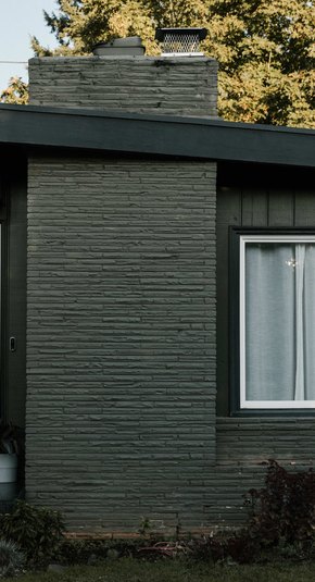The front entrance of a midcentury ranch outside of Portland, painted black