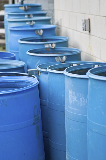 Blue rain barrels in a row flowing into each other