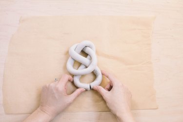 Closing tails of air dry clay sculpture to form a knot