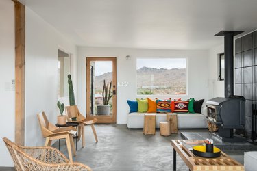 A seating area around a wood burning fireplace with door to patio.