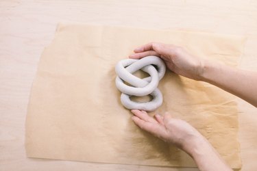 Pushing sides of air dry clay sculpture together to form tighter knot