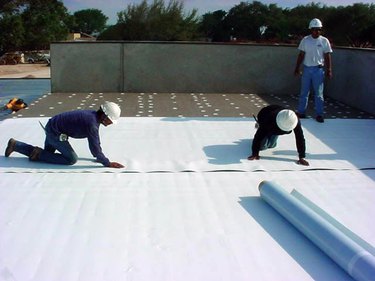 Laying TPO roofing sheets.