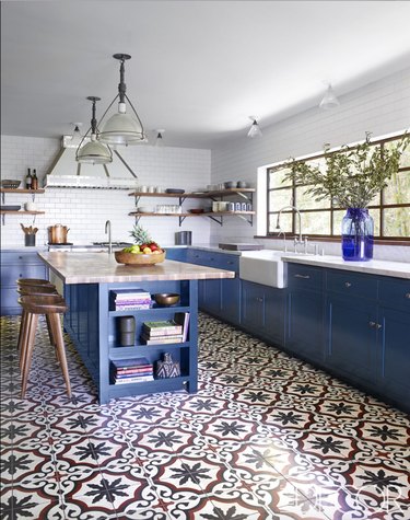 Moroccan kitchen floor tiles with blue cabinets and white countertops