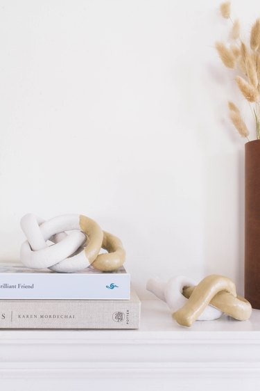 two diy clay knot sculptures on mantel with books