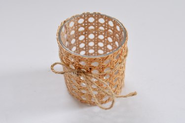 cane wrapped around glass with jute string tied around.