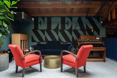 Mezzanine-level office space with blue and red furniture and piano