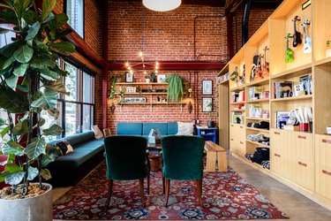 Waiting area with turquoise seating and exposed brick wall