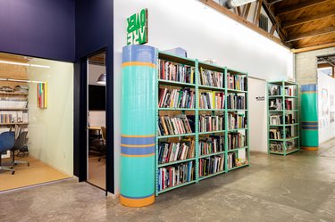 Large turquoise book against wall in open space with cement floor