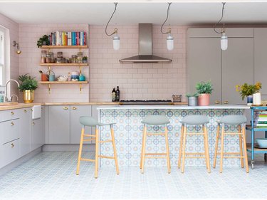 Pink tiled kitchen with light blue tile below.