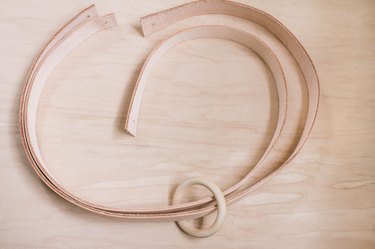 A wood ring slid onto two leather strips
