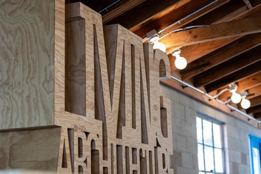 Wood art sculpture of letters below wood-beam ceilings