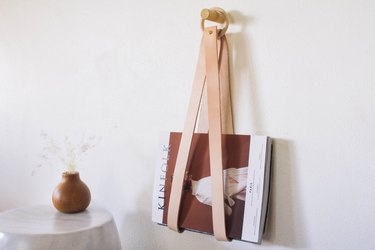 diy leather & wood magazine holder hanging on wall with kinfolk magazine inside