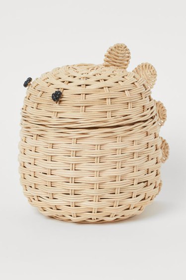 storage basket with two black dots for eyes and dinosaur scales on the back