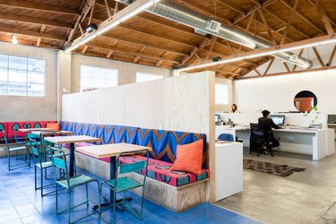 Large corner banquettes with patterned textile wood tabletops and blue chairs