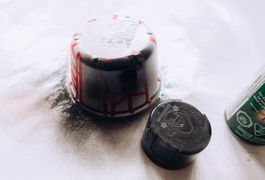 Spray painting jar with black paint