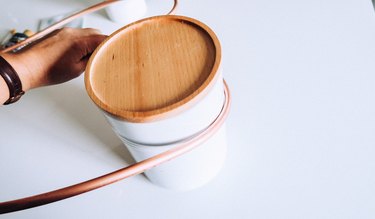 Bending copper piping around circular vessel.