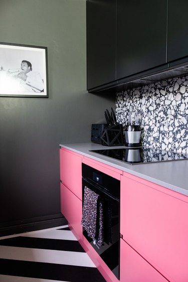 striped black and white kitchen floor with pink and black cabinets