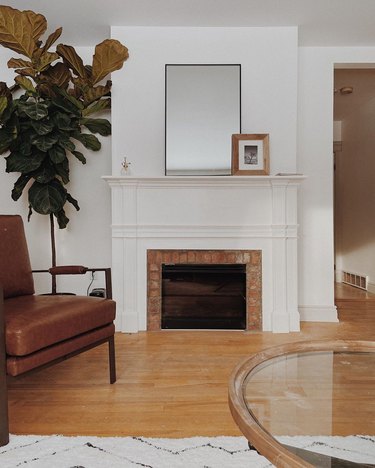 white Craftsman style fireplace with brick accent and white surround in living room
