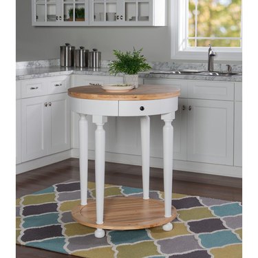 Small round kitchen island in white with wood countertop in white cabinet kitchen