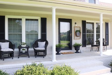 farmhouse style porch with black chairs and black window shutters