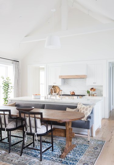 wood trestle table with gray kitchen island with bench seating