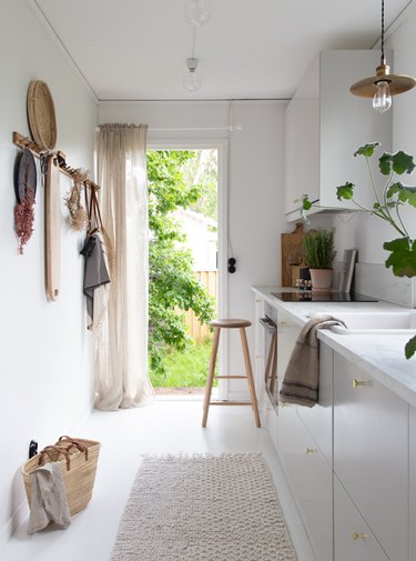 Scandinavian farmhouse kitchen with woven pieces and white cabinets