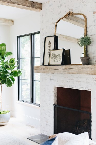 wood mantel with white washed brick fireplace