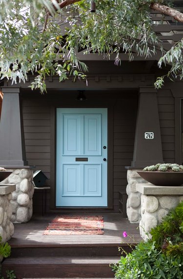 blue Craftsman-style door paired with dark brown siding