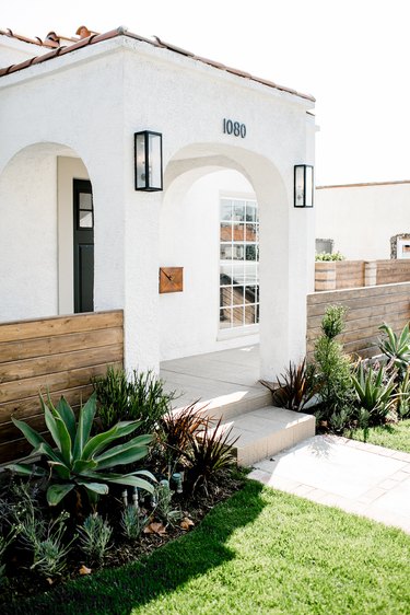 Desert style home with white exterior and terra cotta roof