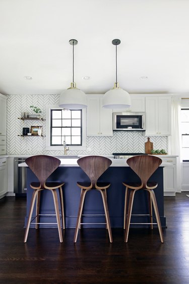 Dark wood kitchen flooring idea with blue island and modern pendant lights