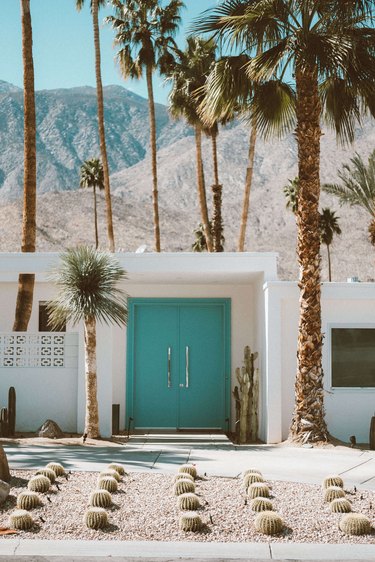 Desert style home in Palm Springs, California with palm trees and turquoise front door