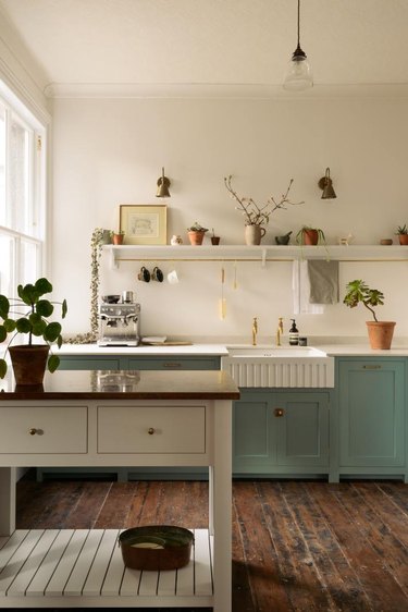 Dark wood kitchen flooring idea with reclaimed wood floor and green cabinets