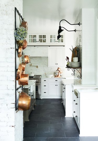white kitchen dark floors with black hardware and dark floors and copper decor