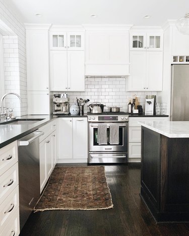 white kitchen dark floors with black countertops and dark hardwood floors