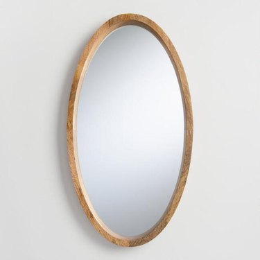 Oval mirror with wooden border in medium finish