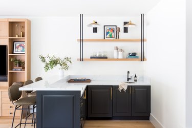 Blue cabinets with white countertop under open shelving
