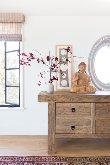 A vintage butcher's table with buddha sculpture and flowers