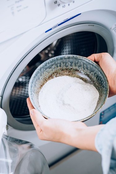 Bowl of washing soda near washing machine.