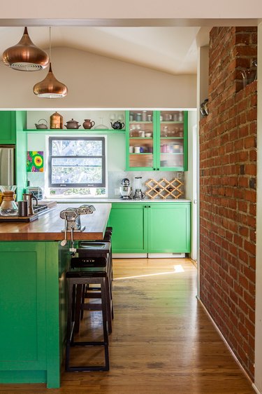 neon green cabinets in kitchen with brick accent wall