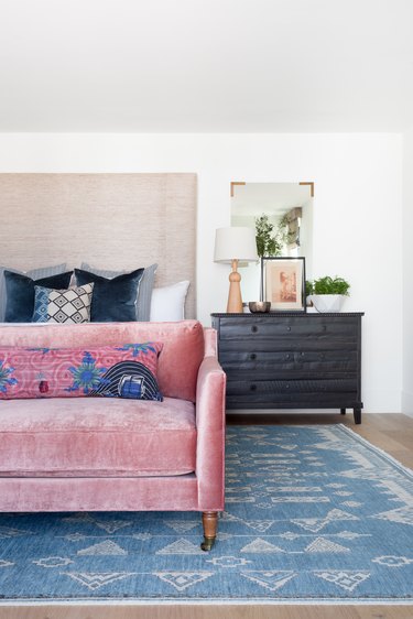 A pink velvet couch in the master bedroom