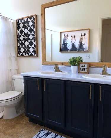 Painted bathroom cabinets before and after featuring navy cabinets and farmhouse decor
