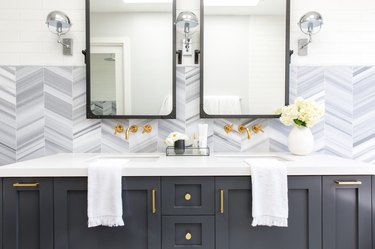 Double bathroom vanity with patterned backsplash and gray cabinets