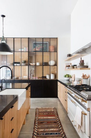 Desert-Themed Kitchen with wood cabinets and white appliances by Amber Interiors Design Studio