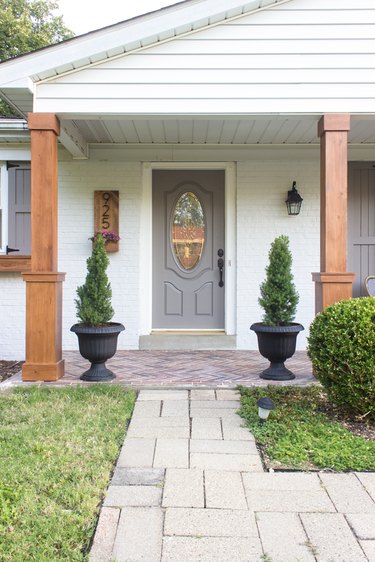 Craftsman front porch with matching wood columns and topiaries