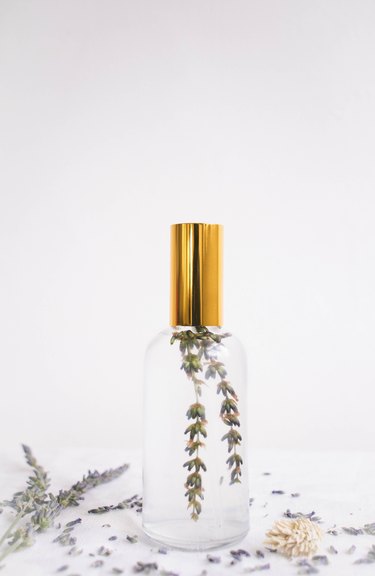 DIY pillow mist in glass bottle with gold top and sprig of lavender inside