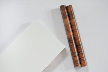 white ikea shelf and roll of walnut contact paper