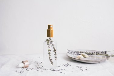 DIY pillow mist in glass bottle with gold top and sprig of lavender inside