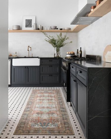 rug for kitchen floor with black cabinets and countertops